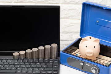 ノートパソコンと豚の貯金箱と手提げ金庫と一万円札