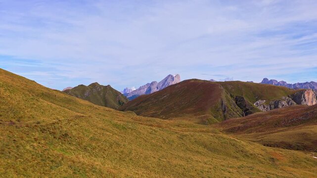 Veduta aerea mozzafiato delle Dolomiti con valli verdi, sentieri alpini e imponenti montagne rocciose sotto un cielo limpido. Un paesaggio naturale spettacolare che rappresenta la bellezza delle Alpi