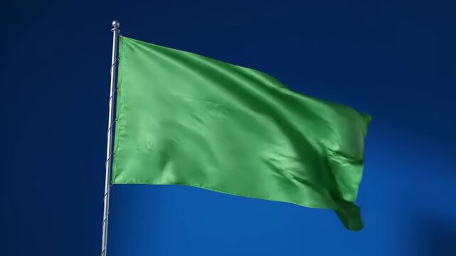 Vibrant Green Flag Waving Against a Deep Blue Sky.