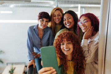 Group of female colleagues taking a photo of themselves in the office