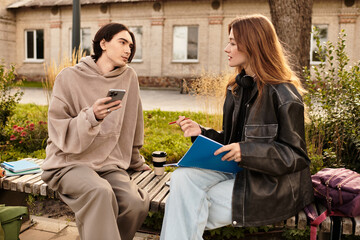 Young couple enjoys a sunny afternoon outdoors with coffee and conversation in a park setting
