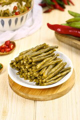 Homemade Pickled Green Beans and Vegetables on Rustic Wooden Table with Fresh Chilies