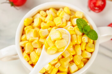 Fresh Golden Sweet Corn Kernels in Bowl with Spoon and Mint Garnish