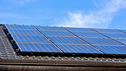 Solar Panels on a Tiled Roof Against a Blue Sky Sustainable Energy