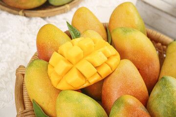 Fresh Hainan Guifei Tree-Ripened Mangoes in Basket with Cut Fruit Showing Sweet Orange Flesh
