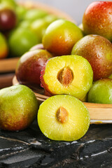 Fresh Ripe Plums Cut in Half Showing Bright Yellow Flesh on Wooden Board