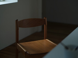 Wooden Chair in Soft Light Against Dark Backdrop Creates an Intimate and Minimalist Scene