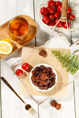 Fujian Gaozhou Dried Litchi Fruit Guiwei Variety with Fresh Tomatoes and Tea on Wooden Table