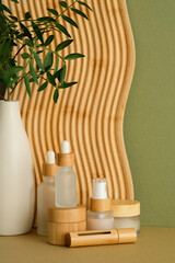 Eco-friendly skincare set with frosted glass bottles, wooden jars, and vase with greenery