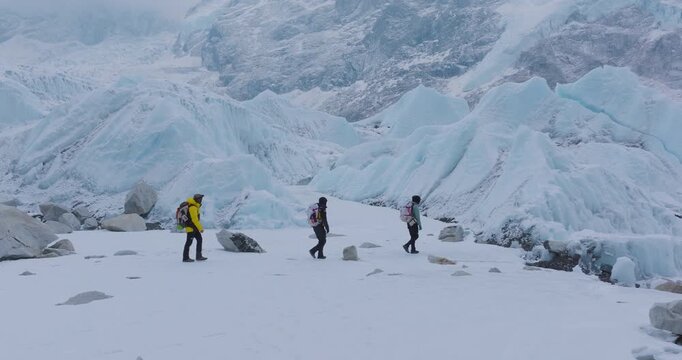 Drone shot of group of tourists hiking Everest Base Camp trek in Khumbu, Nepal. Snow-capped 8000m Himalayan peaks, adventurous trails, and moments of struggle reveal peace, calm, and lifetime travel