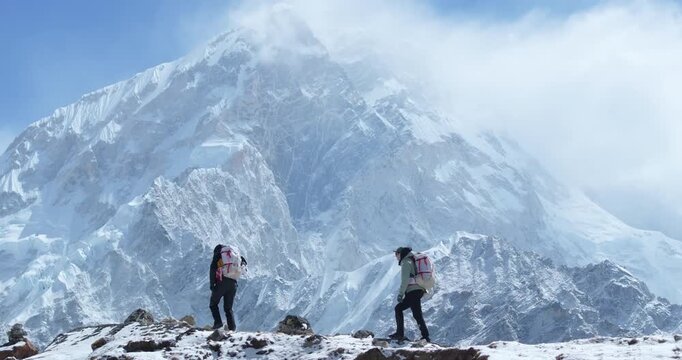 Drone shot of tourists climbing on Everest Base Camp trek in Khumbu, Nepal. Morning sunshine reveals snow-capped 8000m Himalayan mountains, breathtaking landscapes heavenly travel feeling