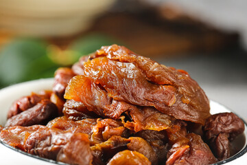 Dried Fukien Lychee Fruit with Wrinkled Brown Flesh Texture in White Bowl