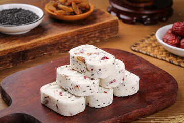 Chinese Eight Treasures Pastry with Walnuts Cashews and Poria on Wooden Cutting Board