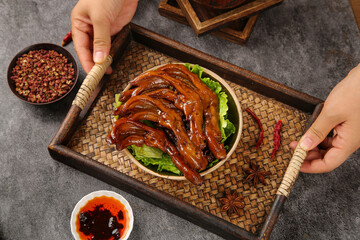Spicy Marinated Duck Feet Traditional Chinese Snack Food Served on Bamboo Tray with Chili Sauce