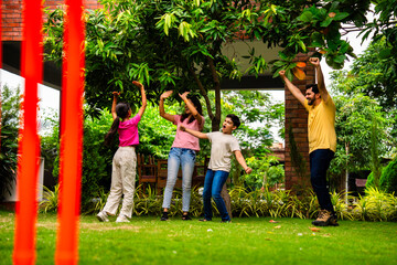 Fototapeta premium Indian family plays cricket bowling at home, enjoying weekend fun with kids in garden