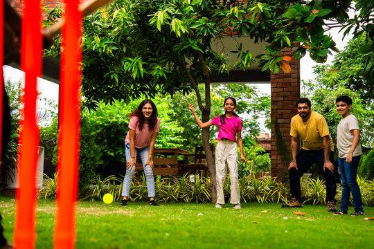 Indian family plays cricket bowling at home, enjoying weekend fun with kids in garden