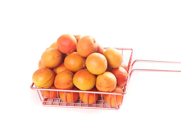 Fresh Xinjiang Apricots in Red Wire Basket on White Background