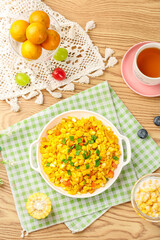 Scrambled eggs with golden corn kernels and fresh vegetables breakfast meal
