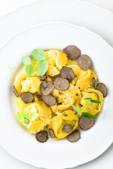 Black truffle ravioli. Italian autumn and winter recipes. Autumn gourmet cuisine of Piedmont, Northern Italy, France, Spain, close up 