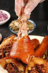 Braised Pork Knuckle Being Pulled Apart with Chopsticks - Traditional Asian Cuisine