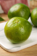Fresh Green Limes on White Plate and Wooden Surface - Citrus Fruit Kitchen Photography