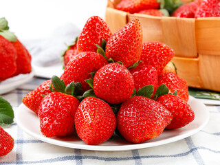 Fresh Red Strawberries Piled on White Plate with Wooden Berry Baskets