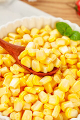 Fresh Golden Sweet Corn Kernels in Bowl with Wooden Spoon