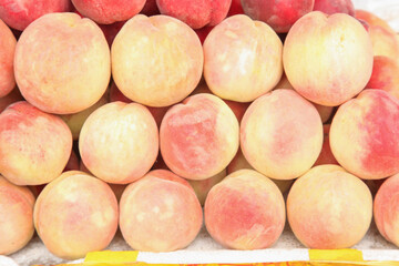 Fresh Ripe Peaches in Piles at Market Display - Organic Stone Fruit Background