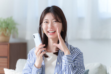 スマホを持って呼びかける若い女性