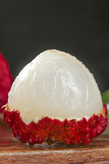 Fresh Peeled Lychee Fruit Close-up with Red Skin and White Flesh on Wooden Background