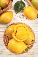 Fresh Ripe Golden Mangoes on Rustic Wooden Background with Wicker Basket Display