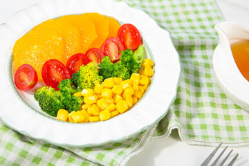 Fresh Mixed Vegetable Salad Bowl with Diced Corn Tomatoes Broccoli and Bell Pepper on Checkered Kitchen Napkin