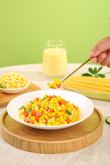 Colorful corn kernels salad with mixed vegetables and prawns on wooden serving board