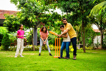 Obraz premium Indian family playing cricket batting joyfully in garden during outdoor bonding time