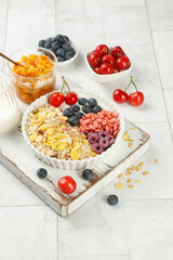 Healthy breakfast bowl with oats berries and yogurt on white wooden tray