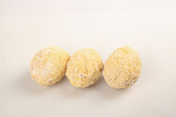 Three Gold Coated Eggs with Textured Surface on White Background