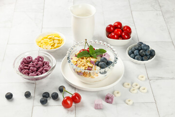 Healthy breakfast oats yogurt bowl with mixed berries fruits and milk on white wooden background