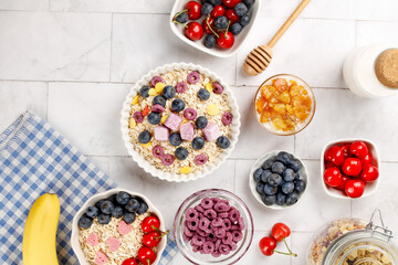 Healthy breakfast bowls with oats berries yogurt and honey on white wooden background top view flat lay