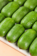 Fresh Mini Kiwi Fruits with Water Droplets in White Tray - Healthy Organic Food Photography