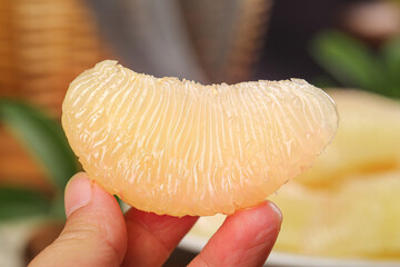 Fresh Juicy Pomelo Segment in Hand - Sweet Citrus Fruit Close-up