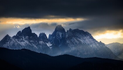 a mountain range is silhouetted against a dark sky