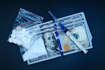 drugs heroin powder and syringe on a black background with dollar banknotes
