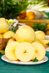 Fresh Golden Yellow Apples Sliced and Whole on Rustic Plate with Mint Garnish