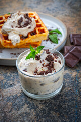 Fresh baked homemade Belgian Brussels waffles with mascarpone cream fresh and dark chocolate topping served as close-up on a design plate