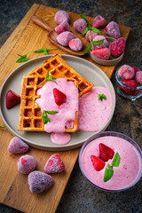 Fresh baked homemade belgian  Brussels waffles with yogurt fresh cream cheese topping dessert and frozen and fresh strawberries