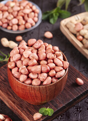 Fresh Raw Peanuts with Red Skin in Wooden Bowl on Rustic Background