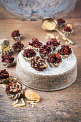 Artisan handcrafted fine dark chocolate pralines with crushed almonds served as close-up on a cake plate