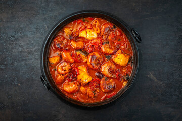 Traditional artisan homemade gambas prawn und fish stew romesco de peix served as top view in...