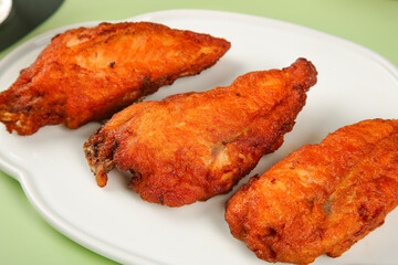 Crispy Fried Chicken Wings with Golden Brown Coating on White Plate