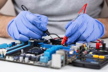 Technician under fixed and repairing computer mainboard process by used multimeter